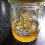 Jar of vegan dandelion honey on a black worktop